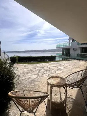 two chairs and a table in front of a building at Panorama Bay-Serenity Haven in Burgas City