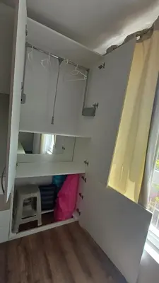 a small room with white cabinets and a pink pillow at Синя пеперуда Blue butterfly in Primorsko