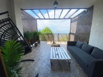 a living room with a blue couch and a balcony at Santa Marina Sun&Sea Haven in Sozopol