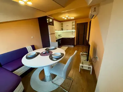 a living room with a table and a purple couch at Two-Bedroom Apartment in the Heart of Burgas, Bogoridi Street in Burgas City
