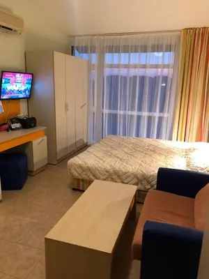 a hotel room with a bed and a television at Elit 2 Apartment in Sunny Beach