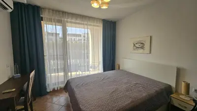a bedroom with a bed and a large window at Vladan apartments in Sozopol