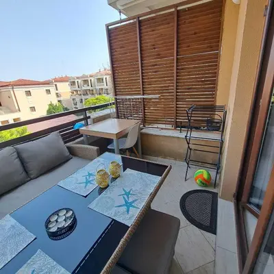 a patio with a couch and a table on a balcony at Vladan apartments in Sozopol