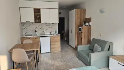 a kitchen and living room with a couch and a table at Vladan apartments in Sozopol