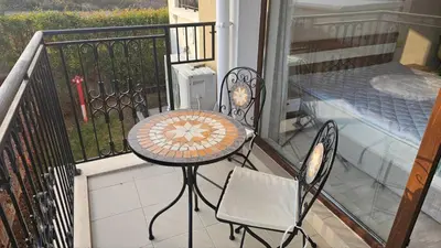 a balcony with a table and chairs and a bed at Vladan apartments in Sozopol