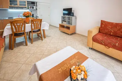 a living room with a table and a couch and a kitchen at Apartment NORA in Sunny Beach