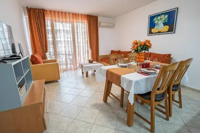 a living room with a table and chairs and a living room at Apartment NORA in Sunny Beach