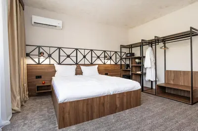 a bedroom with a large bed and a book shelf at Noma Boutique Hotel - Adults only in Sunny Beach