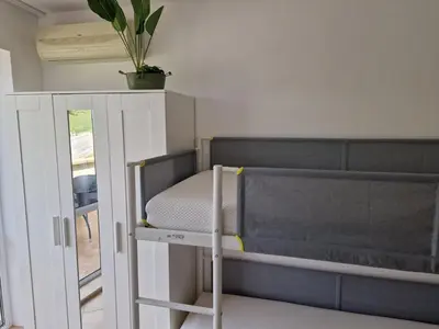 a small bedroom with a bunk bed and a mirror at SunBreeze Living Apartments in Byala