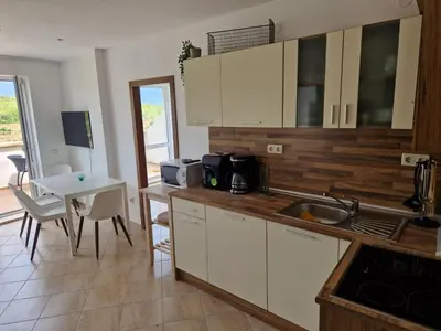 a kitchen with a sink and a table with a tableablish at SunBreeze Living Apartments in Byala
