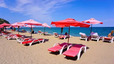 a group of chairs and umbrellas on a beach at Бяла Виста Бийч Апартментс A - Byala Vista Beach Apartments A in Byala