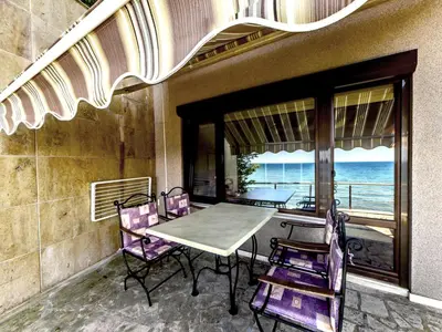 a table and chairs on a balcony with a view of the ocean at Hotel Continental in Kiten