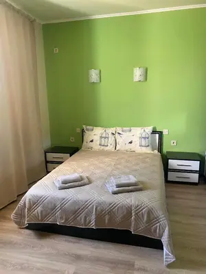 a bedroom with a large bed with green walls at Rose Villa in Trŭstikovo