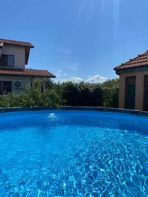 a large blue swimming pool in front of a house at Rose Villa in Trŭstikovo