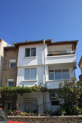 a white building with a fence in front of it at Megi Apartments in Sozopol