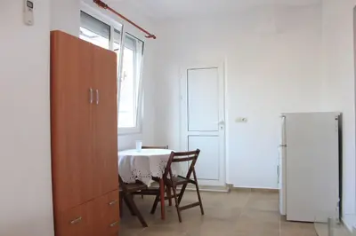 a dining room with a table and chairs and a window at Megi Apartments in Sozopol