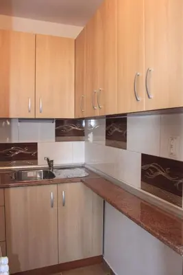 a kitchen with wooden cabinets and a sink at Megi Apartments in Sozopol