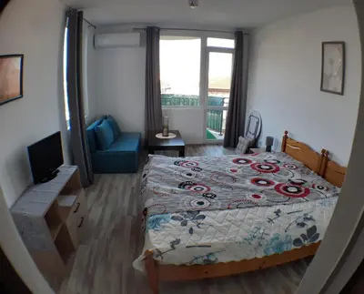 a bedroom with a bed and a couch and a window at Sunshine Byala 2 in Byala