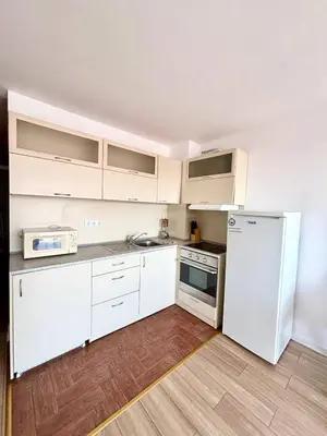 a kitchen with white cabinets and a white refrigerator at 17 pools in Fort Noks Grand in Sveti Vlas