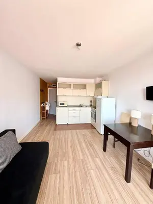 a living room with a table and a kitchen at 17 pools in Fort Noks Grand in Sveti Vlas