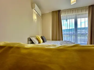 a bedroom with a large bed with a large window at Menada Sea Dreams Apartments in Sveti Vlas