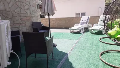 a group of chairs and an umbrella on a patio at Sunshine Byala in Byala