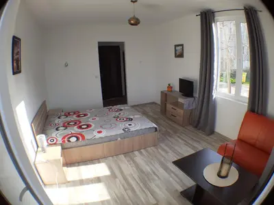 a bedroom with a bed and a table and a mirror at Sunshine in Byala