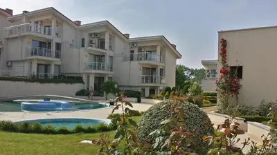 an apartment building with a swimming pool in front of it at Villa Sun Village Byala in Byala