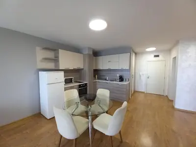 a kitchen with a glass table and white chairs at Sunset in Chernomorets