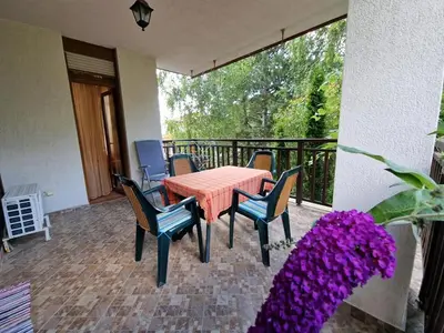 a patio with a table and chairs on a balcony at Marina Trio in Sozopol
