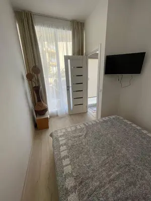 a bedroom with a bed and a flat screen tv at Aqva blue apartments in Sunny Beach