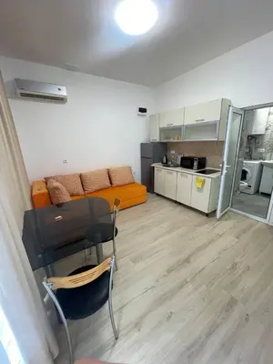 a room with a desk and a couch and a kitchen at Aqva blue apartments in Sunny Beach