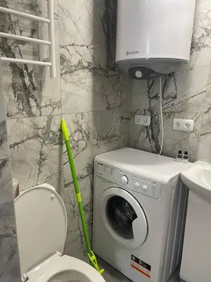 a bathroom with a washing machine and a toilet at Aqva blue apartments in Sunny Beach