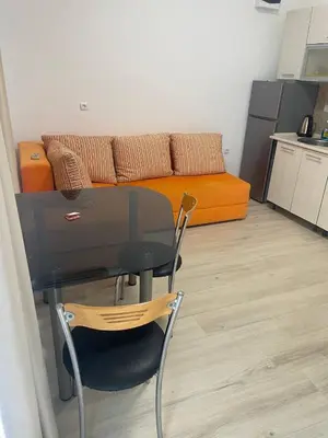 a glass table and chair in a living room with a couch at Aqva blue apartments in Sunny Beach