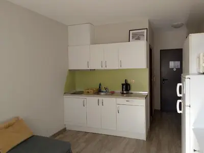 a small kitchen with white cabinets and a refrigerator at Sorrento Sole Mare Studio A Bastet BS in Sveti Vlas