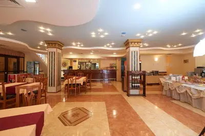 a restaurant with tables and chairs and a bar at Hotel Smolyan in Sunny Beach