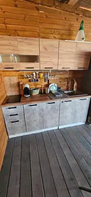 a kitchen with wooden walls and a wooden floor at Каравана Сий-я-на in Sozopol