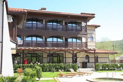a building with a balcony with benches in front of it at Семеен хотел Звезда in Sŭdievo