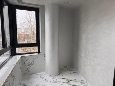 a white room with a column and a window at Luxury Apartment with Parking Just Steps from the Beach in the Heart of Burgas! in Burgas City