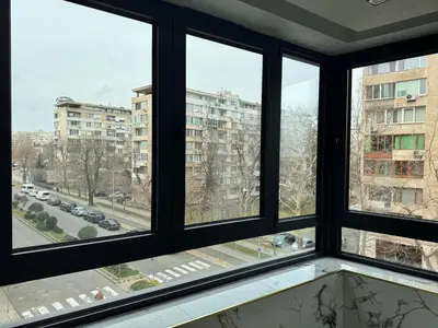 a room with four windows with a view of a street at Luxury Apartment with Parking Just Steps from the Beach in the Heart of Burgas! in Burgas City