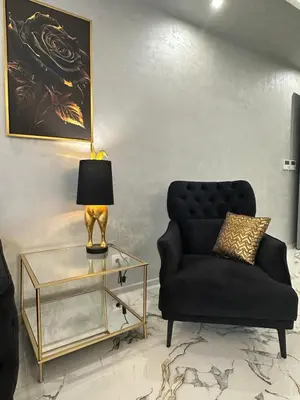 a living room with a black couch and a glass table at Luxury Apartment with Parking Just Steps from the Beach in the Heart of Burgas! in Burgas City