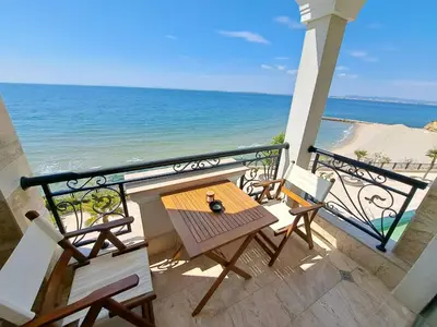 a balcony with a table and chairs and the beach at Onyx Private Apartments in Sveti Vlas