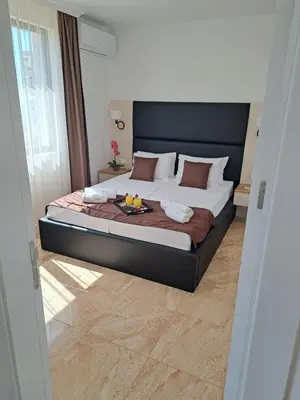 a bedroom with a large bed with a tray on it at Onyx Private Apartments in Sveti Vlas