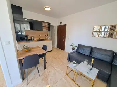 a living room with a black couch and a table at Onyx Private Apartments in Sveti Vlas