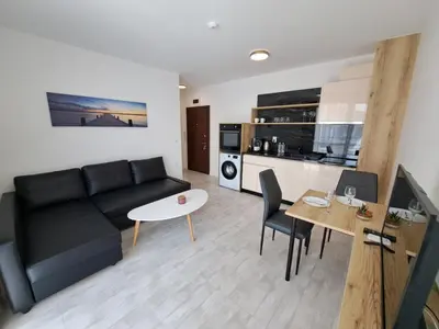 a living room with a black couch and a table at Onyx Private Apartments in Sveti Vlas