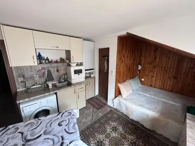 a small kitchen with a bed and a sink at Studio 007 с градинка in Burgas City