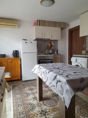 a kitchen with a table in the middle of it at Studio 007 с градинка in Burgas City