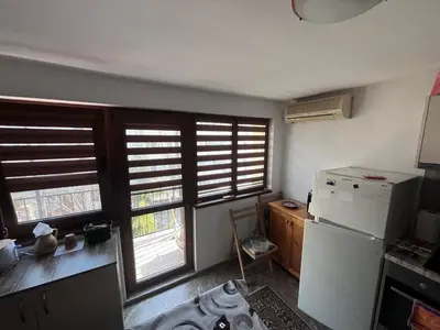 a kitchen with a refrigerator and some windows at Studio 007 с градинка in Burgas City