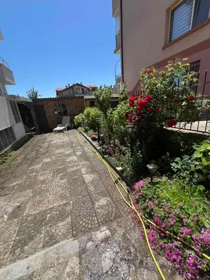 a garden with flowers and a yellow hose next to a building at Luxury Apartment Saint George Beauty and Style in Sveti Vlas