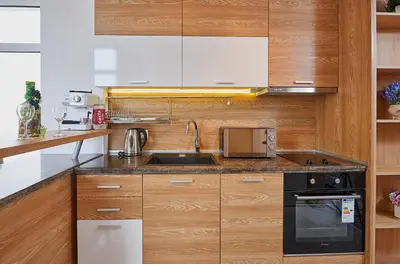 a kitchen with wooden cabinets and a sink at Luxury Apartment Saint George Beauty and Style in Sveti Vlas